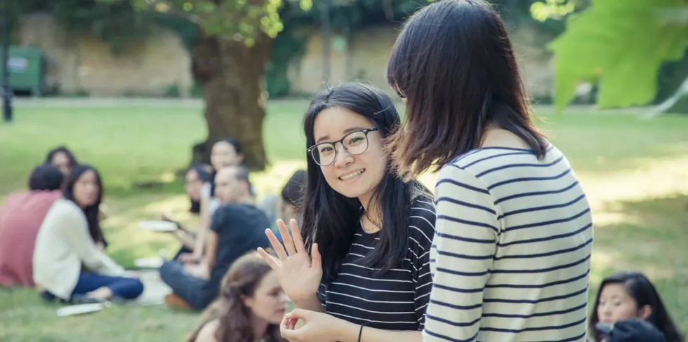 A group of people sitting on the grassDescription automatically generated with low confidence